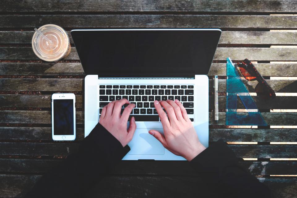 カフェでノートパソコンを開いて学習する学生